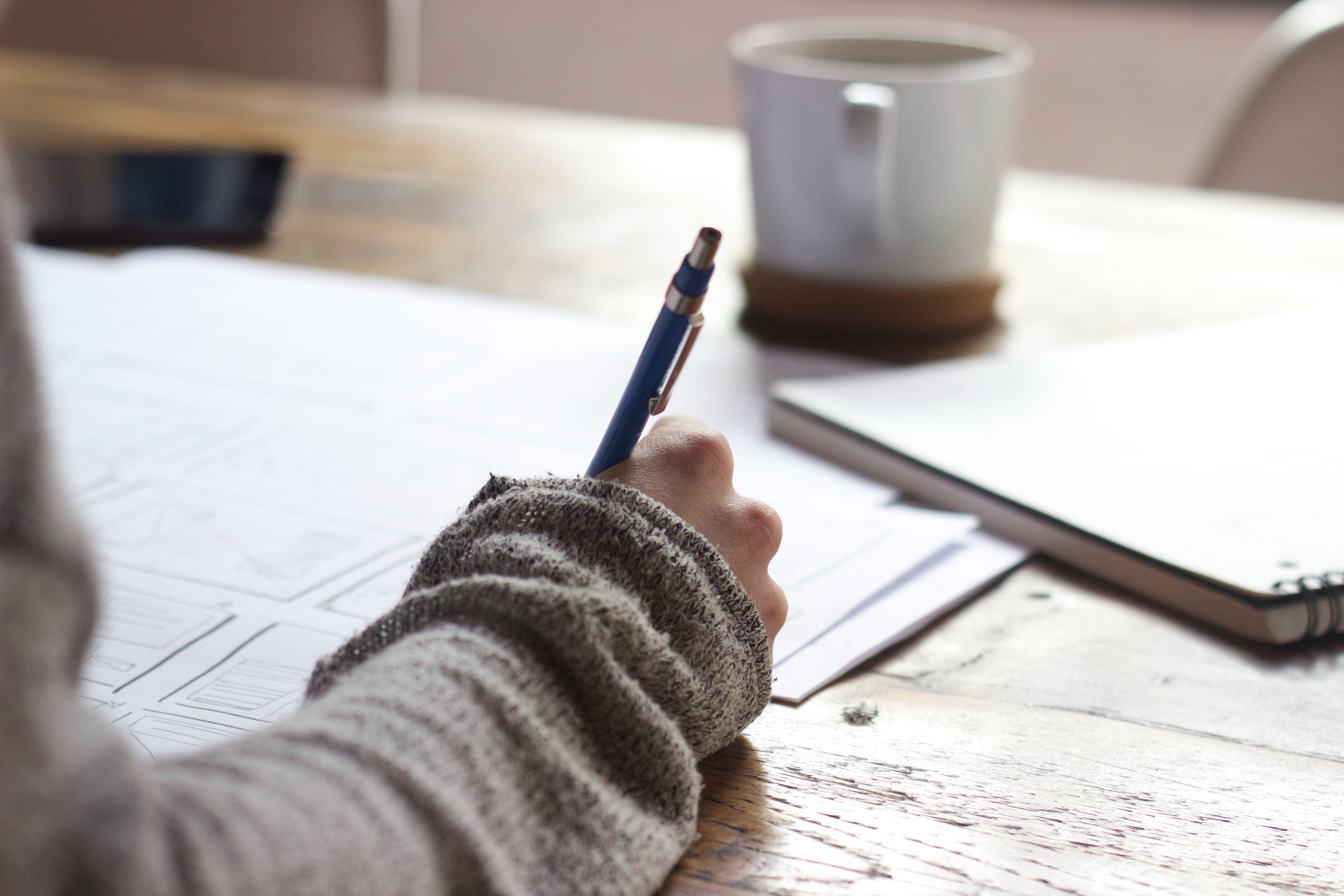 man writing down on a paper